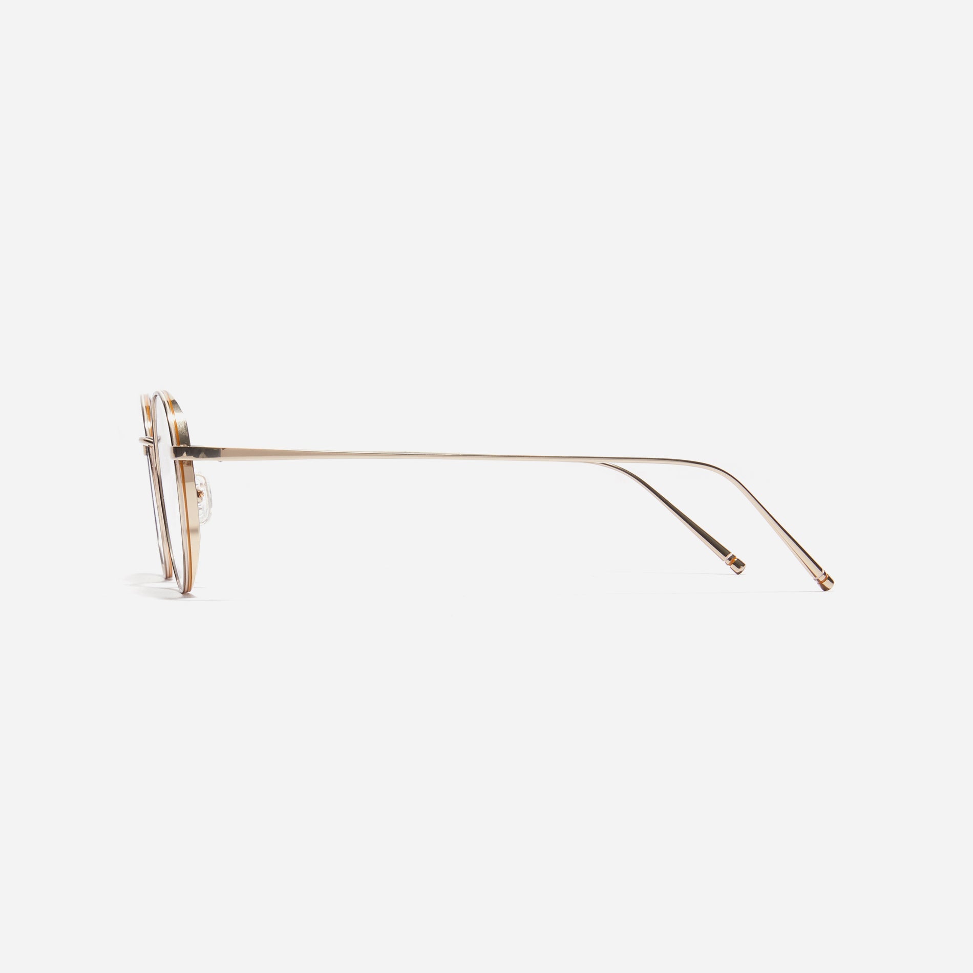 Round-shaped titanium eyeglasses inspired by the aesthetics of platform shoes. Their dual-rim structure effortlessly accommodates the use of thick lenses for higher prescriptions, while retro vibes shine through side color accents applied using epoxy techniques.